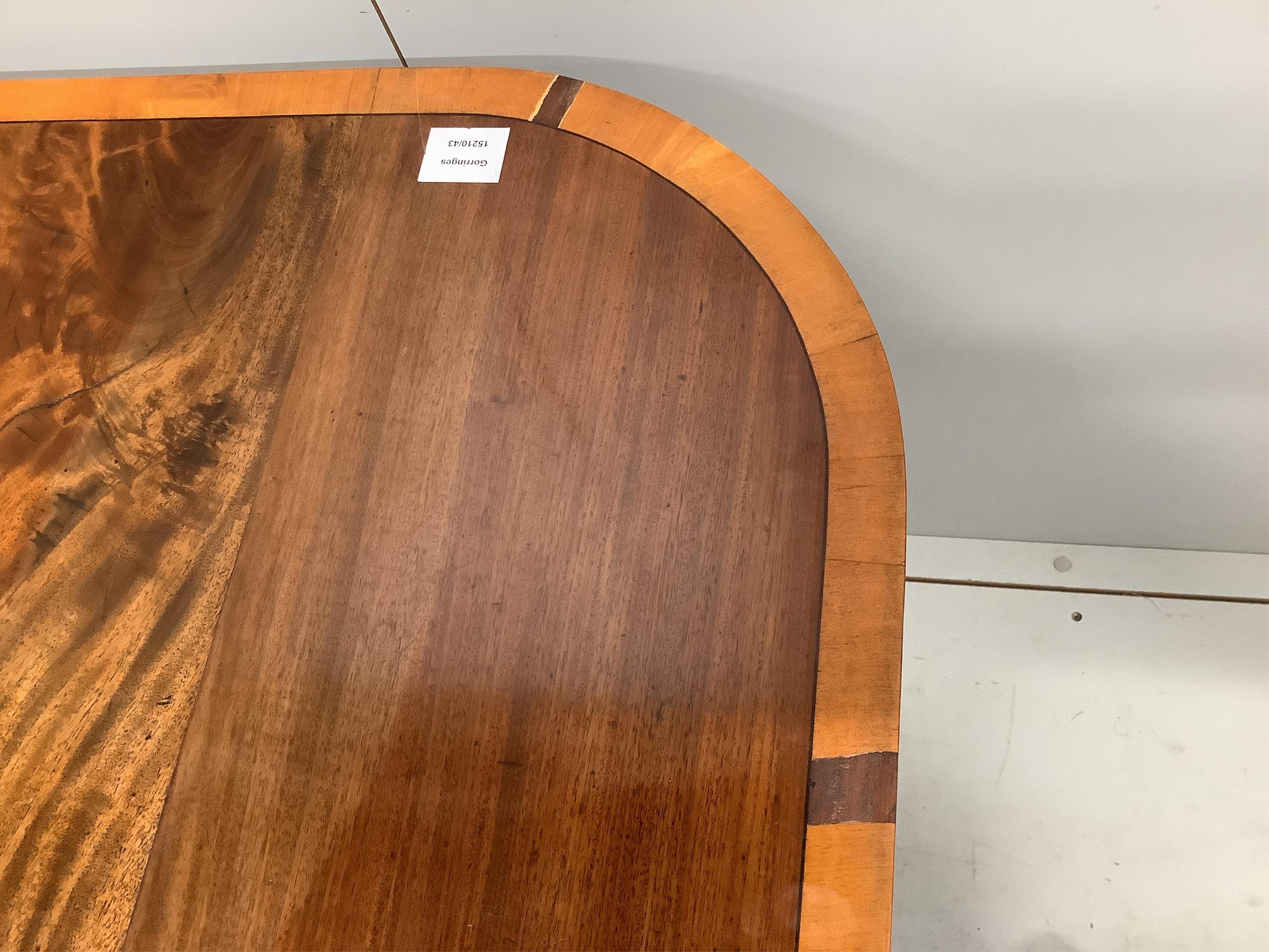 A George IV satinwood banded mahogany twin pedestal dining table, 223cm extended, one spare leaf, depth 106cm, height 74cm. Condition - fair to good